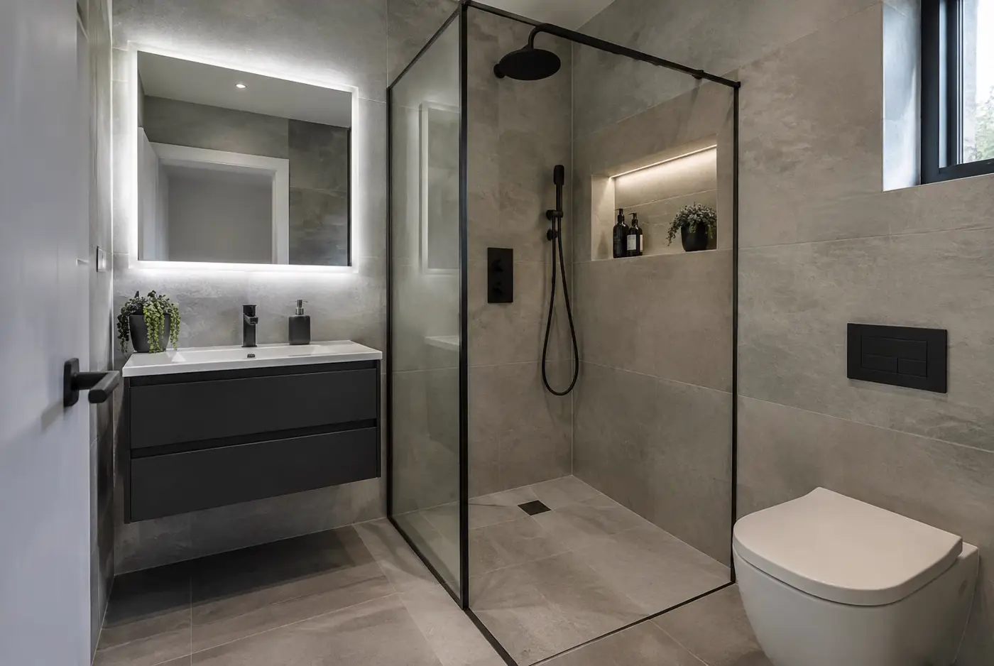 Chester en-suite with black framed walk-in shower, grey stone-effect tiles and wall-hung toilet